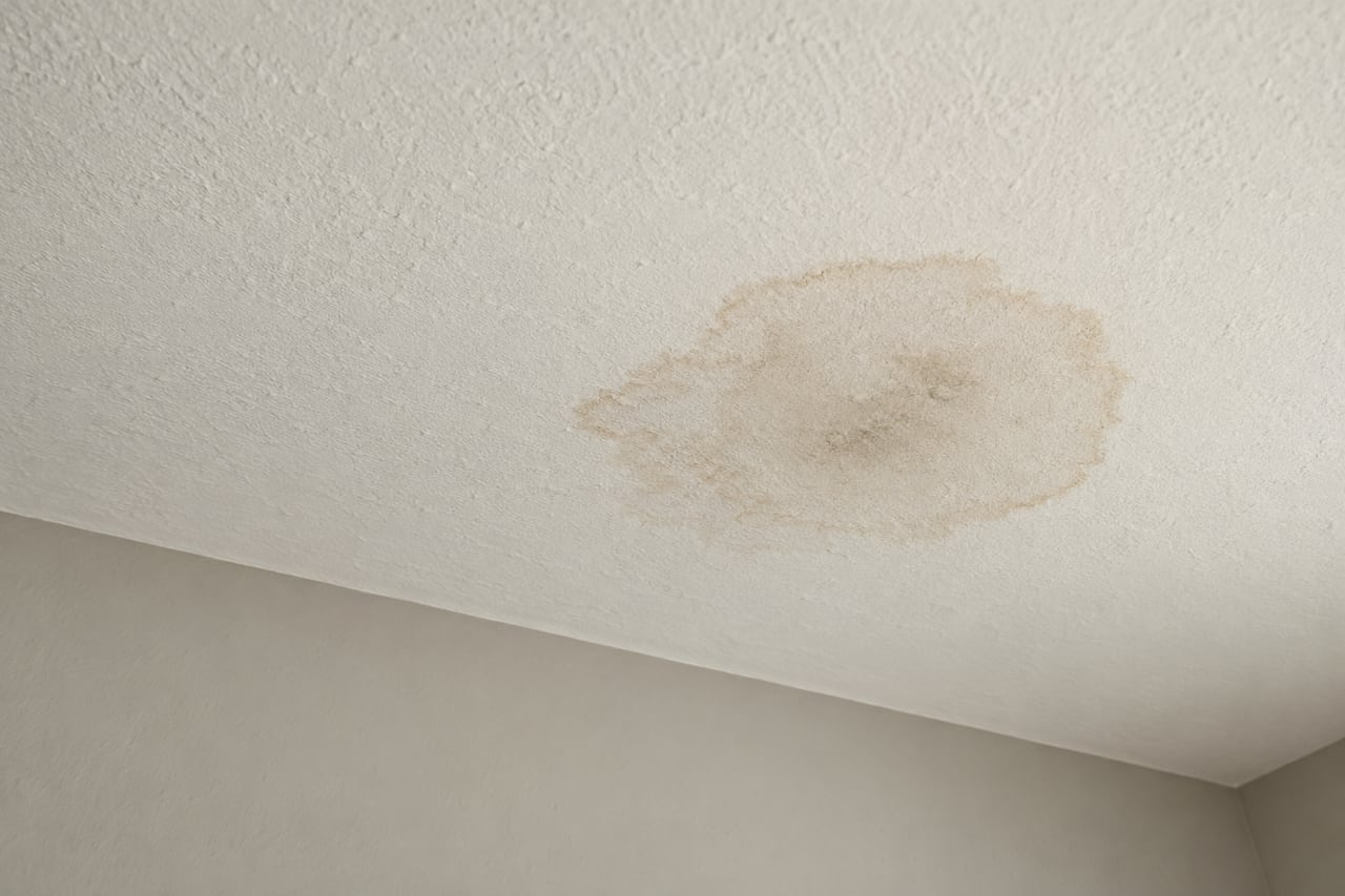 Illustrative water stain on an intact textured ceiling near an interior wall